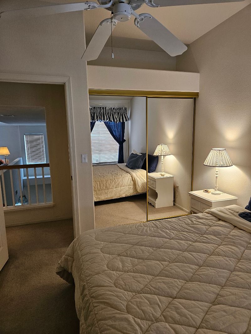 Second bedroom with ceiling fan and mirrored closet