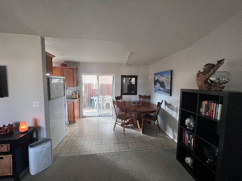 Dining room off the living room and kitchen with patio door access to outdoor table and chairs.