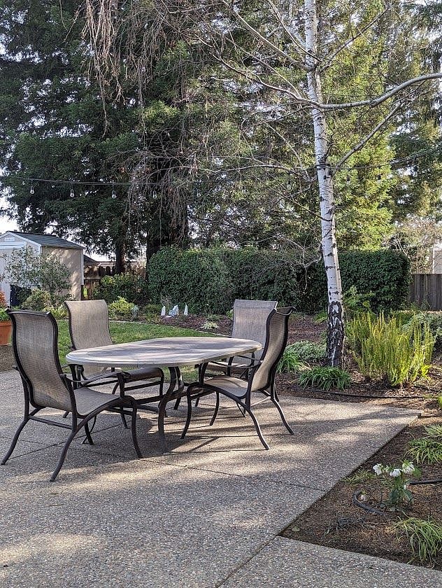 Patio with mature landscaping and an organic vegetable garden.