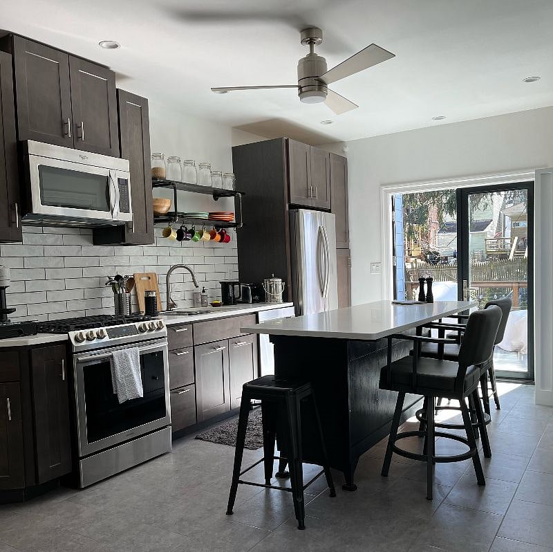 Fully stocked kitchen with comfortable island stools over looking back deck