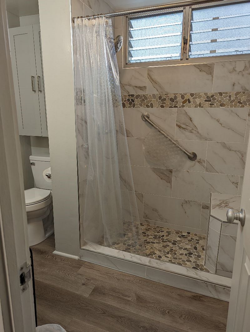 Awesome shower with a seat! 
And extra storage over the toilet with containers for your personal items.