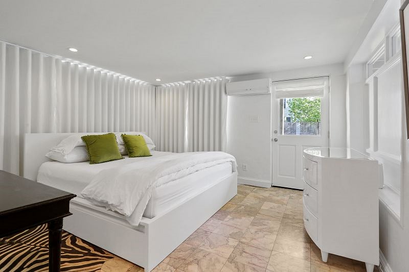 The bedroom is wrapped in custom linen blackout curtains.