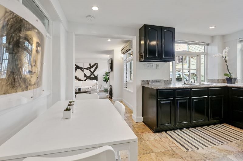 The kitchen contains a dining table. The apartment is decorated with local and original art.