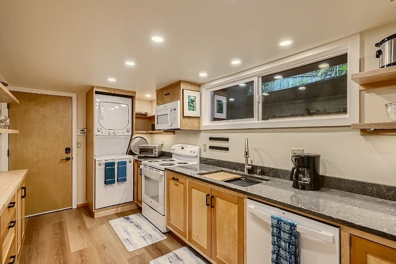 Stacked washer and dryer are located in kitchen. Door leads to assigned garage parking.