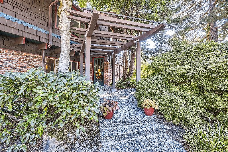 Main home entrance with walkway to apartment on the right.