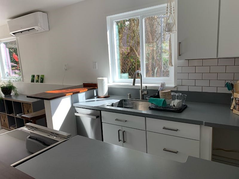 Kitchen area with dishwasher, stove/oven, small fridge, good amount of storage and prep area.
Bar with two barstools.