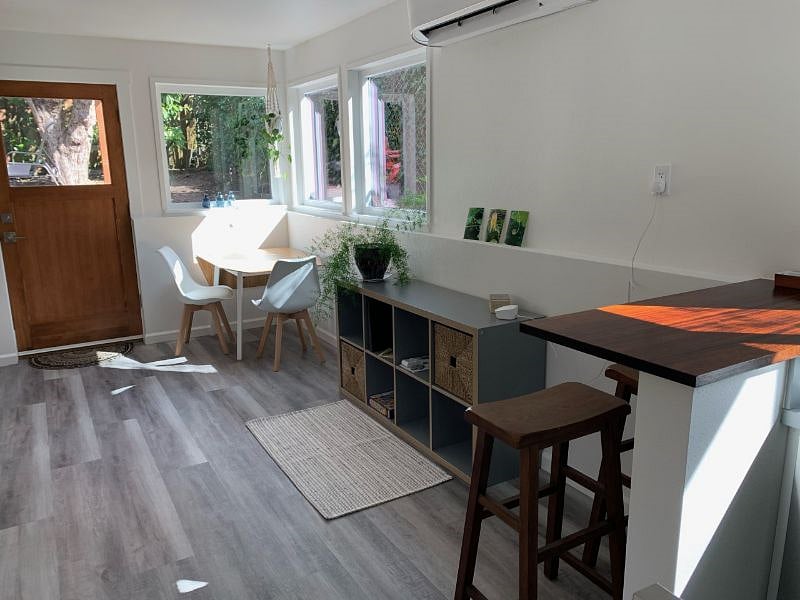 Seating area with 2 chairs, windows looking out in patio area.
