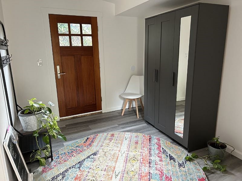 Entrance room, featuring a closet, chairs, and a coatrack.