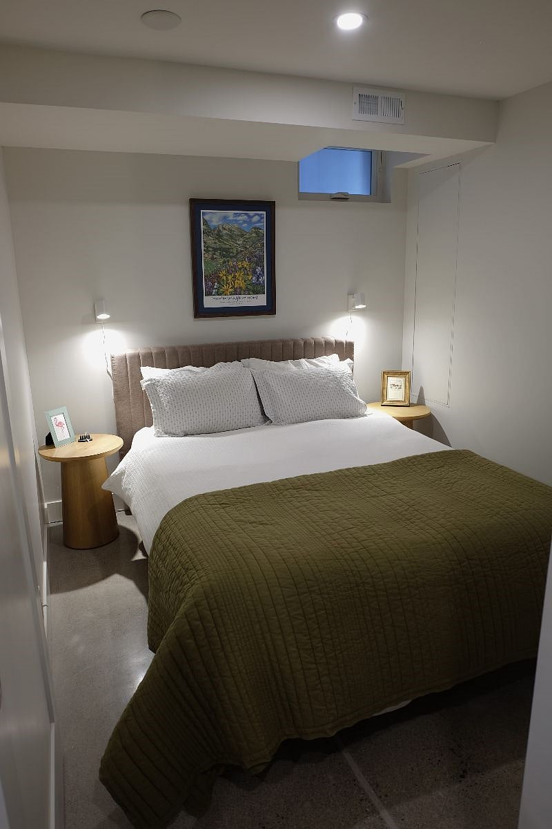 Bedroom with queen bed, tempurpedic mattress, and side lamps.