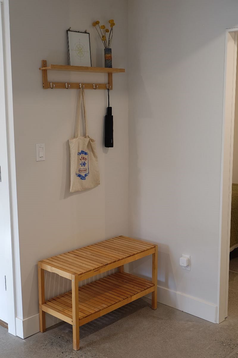 Entry area at the bottom of the stairs. There are additional coat hooks at the top of the stairs.