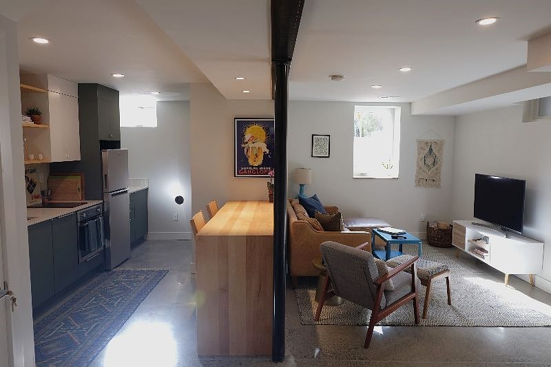 Wide angle, full view of kitchen and counter seating that is open to the main living area.