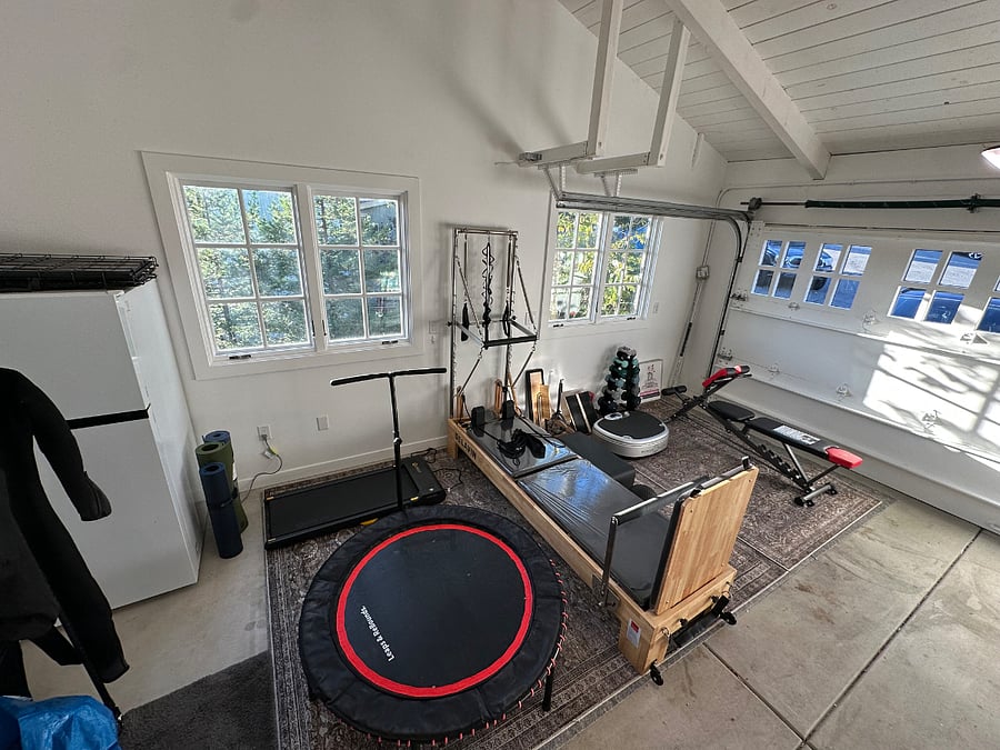 Light-filled workout area. Powered walking treadmill, Leaps and Bounds rebounder, Full, high-quality Pilates reformer, Power Plate, yoga mats, lifting bench and free weights. Peloton added but not shown in photo.