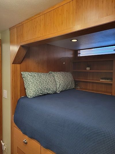 Bed with additional shelving and storage around it.