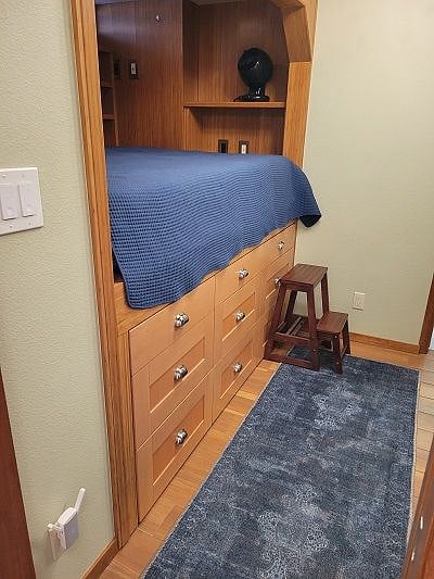 Nine (9) drawer custom dresser below bed frame.