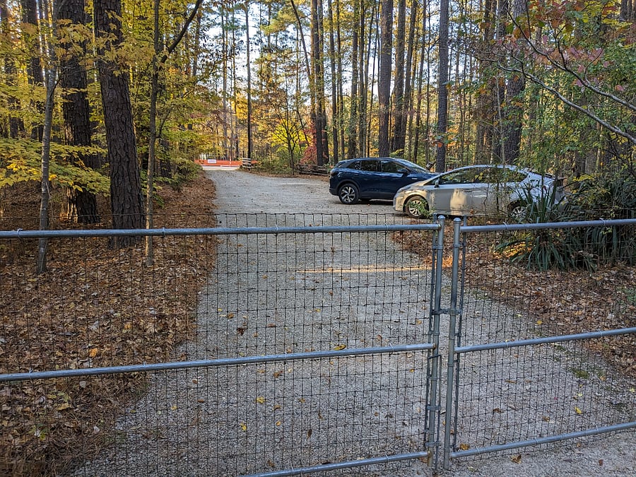 Front parking outside the unlocked gate and also next to the kitchen. Orange netting in distance shows where the Greenway path is (now completed)