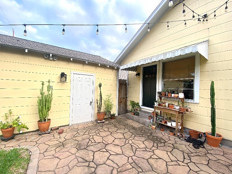 Back yard patio with string lights and view of garage.