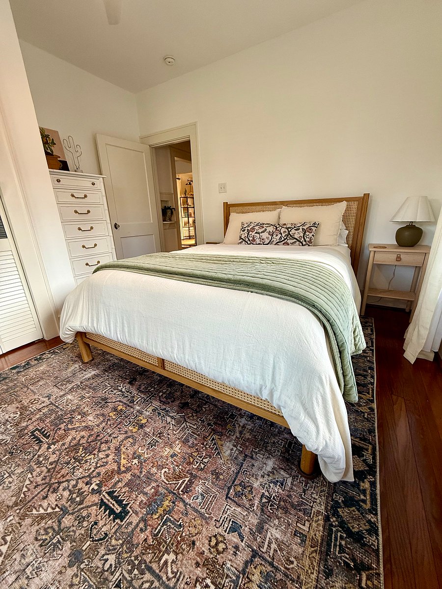 Secondary bedroom with queen size bed, 2 bed side tables, tall dresser, and closet.