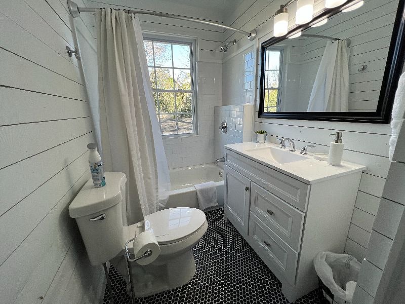 Completely redone bathroom with shiplap walls and beautiful tile.