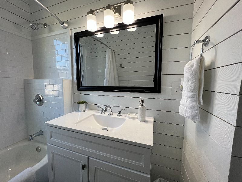 Completely redone bathroom with shiplap walls and beautiful tile.