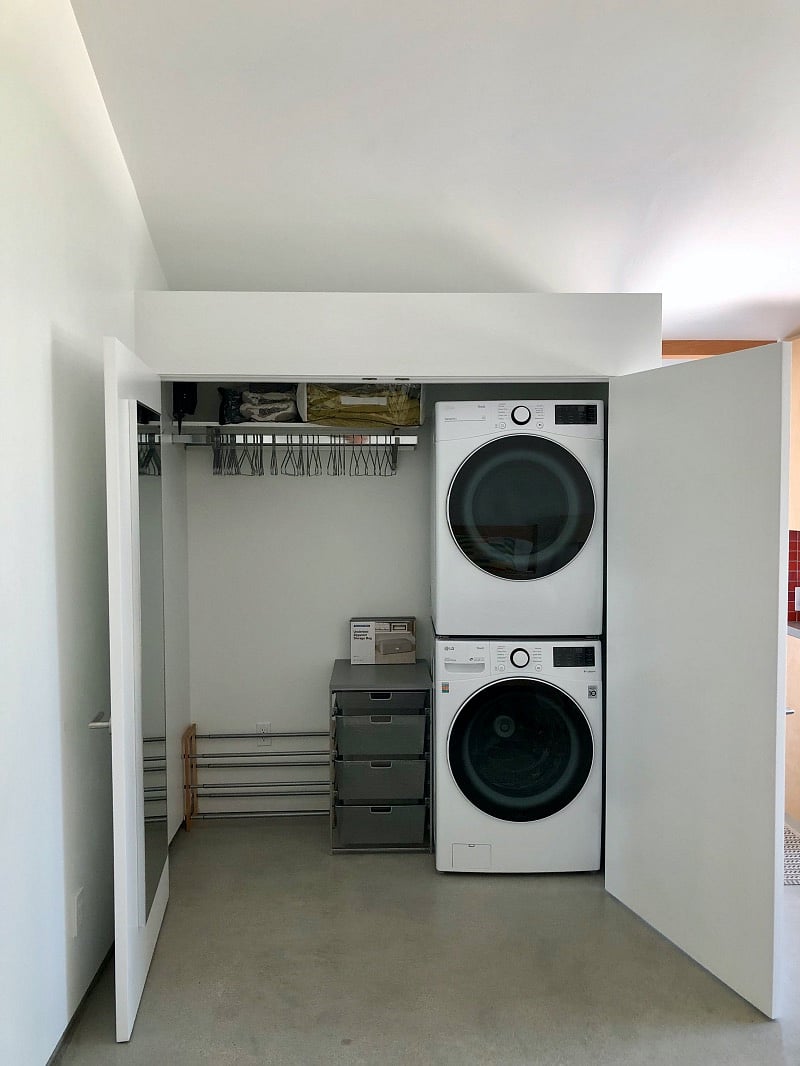 Spacious closet with shelves for storage and full-length mirror on the interior door. High-capacity washer dryer.