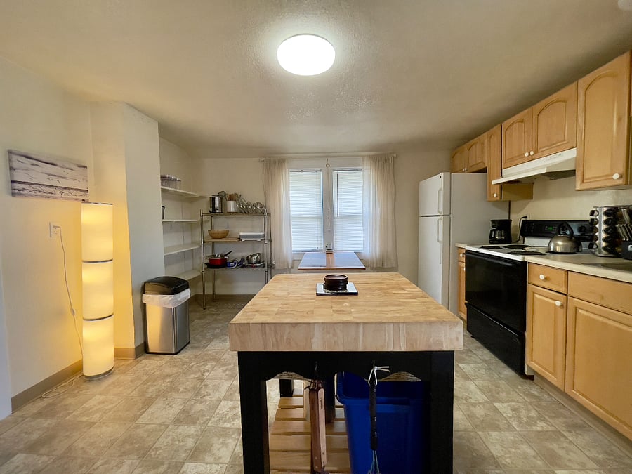 Fully stocked eat-in kitchen with center island, appliances, and cookware.
