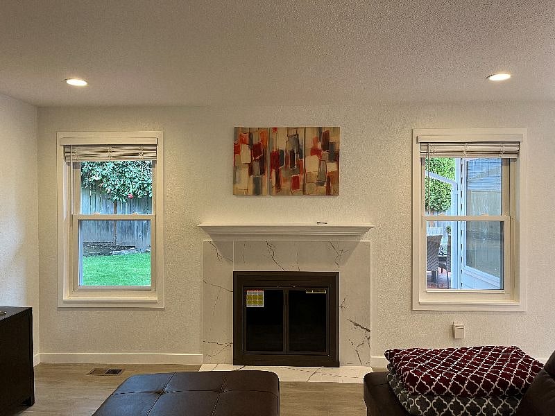 Living room fireplace and windows that open onto the back yard