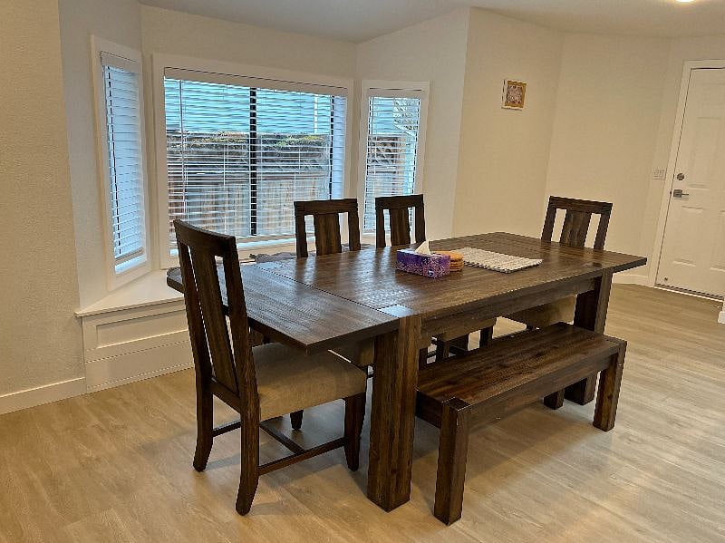 The dining area features bay windows and a dining table for six