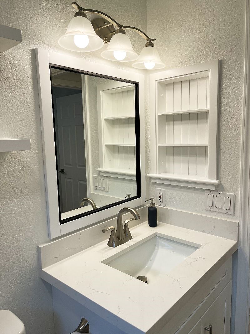 The guest bathroom vanity features built-in storage