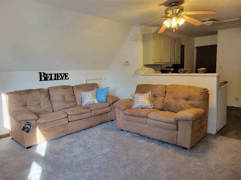 Open Concept Living Room/Kitchen showing couch, love seat, and kitchen cabinets