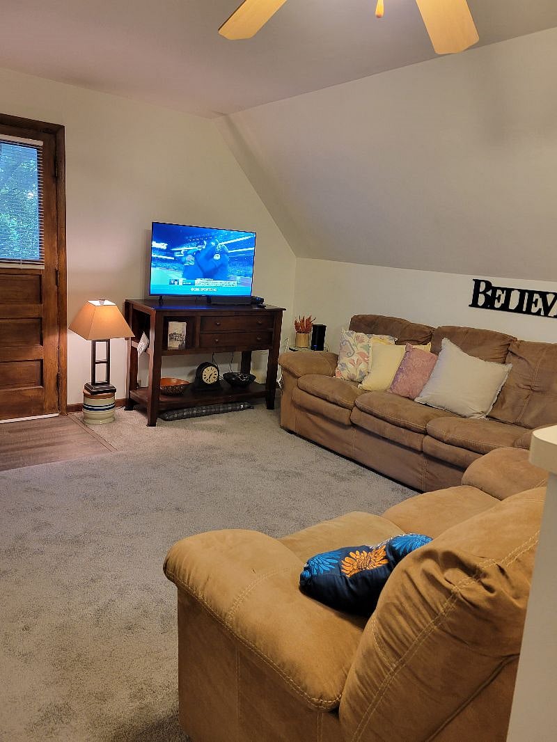 Living Room showing door to the balcony, couch, 43" Smart TV, TV stand / buffet