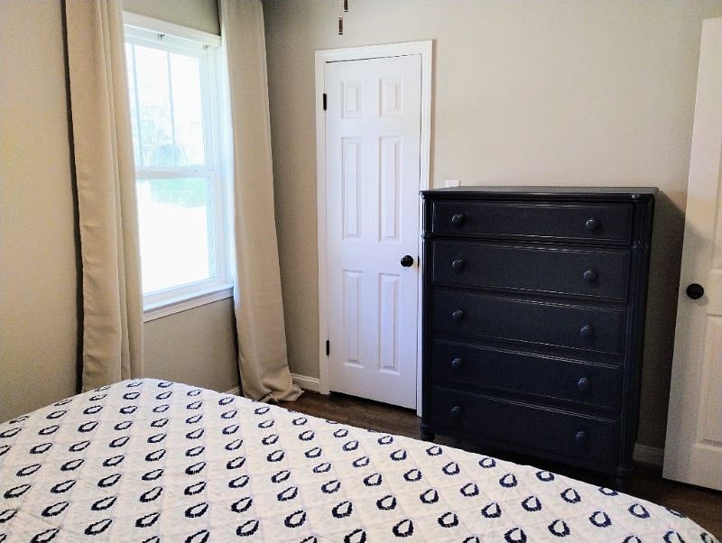 Guest bedroom has a bureau and step-in closet