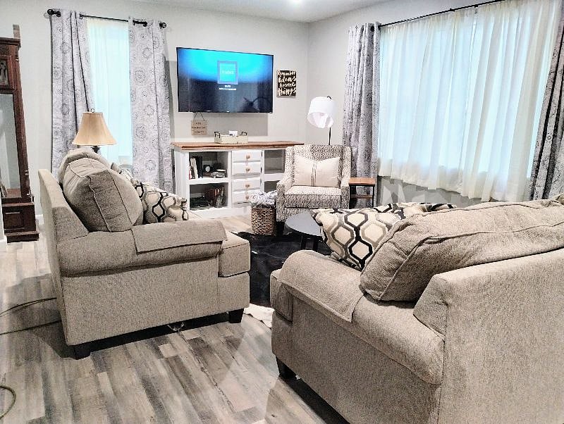 Living room has a comfortable couch and loveseat and reading chair with lamp. Light filtering drapes and blackout drapes on the windows. 56 in Smart TV with Wi-Fi included throughout the home