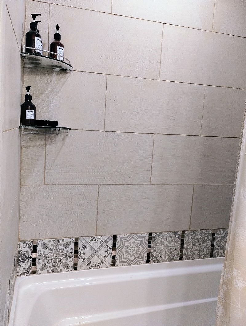 Hall bath has tub shower with tile surround and bath products included