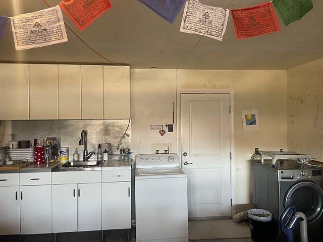 Garage with cabinets, full sink, and full-seized washer and dryer.
