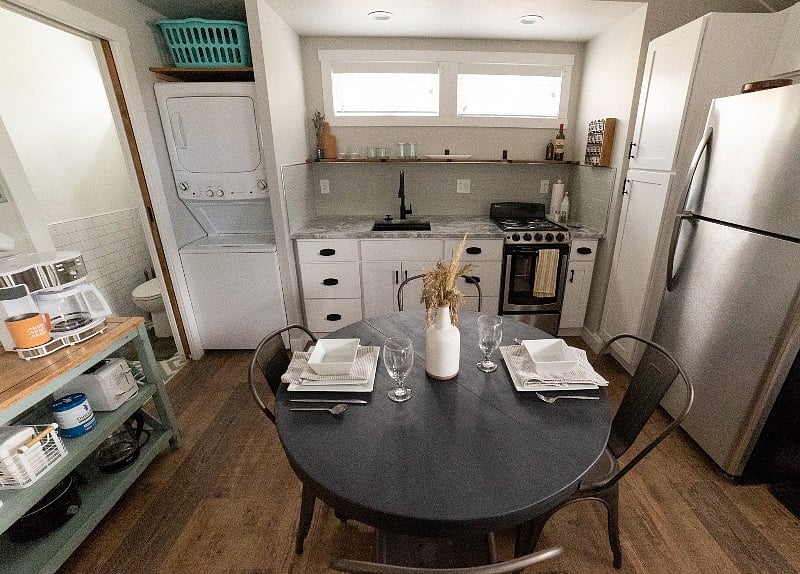 The dining area with kitchenette and washer/dryer in the background
