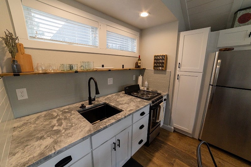 A beautiful kitchenette with a full size refrigerator/freezer and plenty of storage. Granite countertop, oven/range, disposal, spice rack.