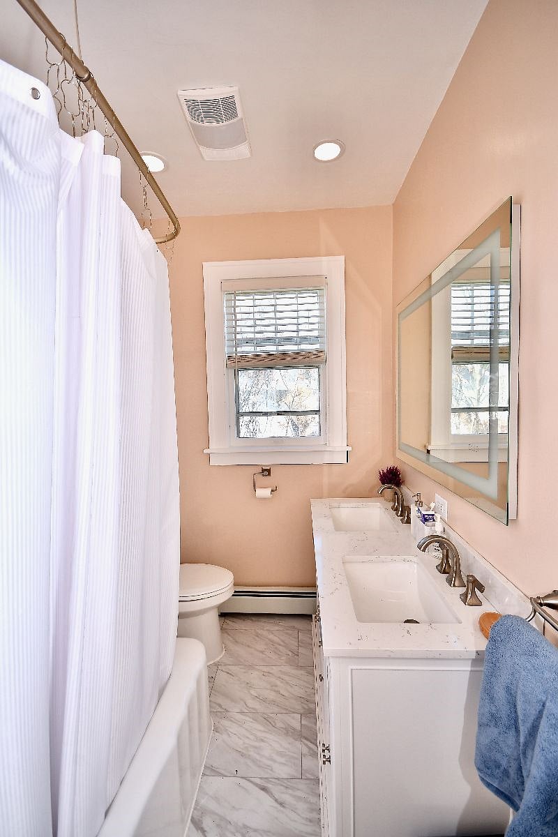 Full sized bathroom #1. LED mirror, double vanity, vintage cast iron tub with shower. 