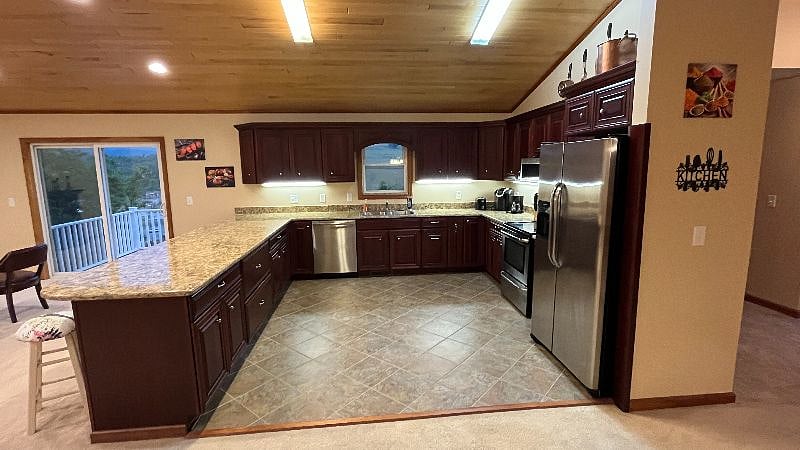 Extra large kitchen with electric stove, refrigerator, microwave, and dishwasher installed. Kitchen is attached to the back deck with gorgeous sunset views.