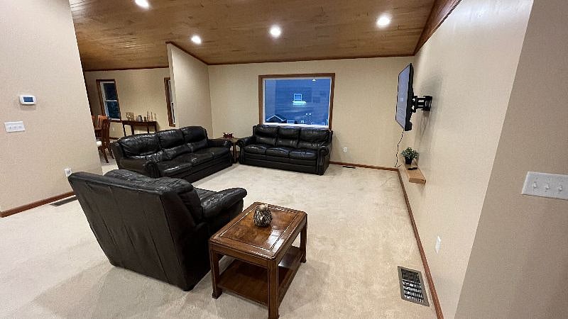 Living room with leather couches and wall mounted 55" flat screen TV.