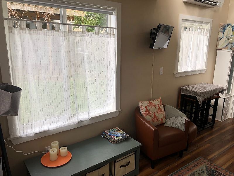 View of main house out of these windows. Curtains let in light but not views, roll-down blinds also installed to block out light.