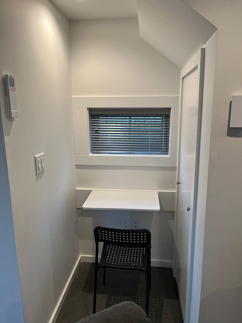 Fold down desk. To the right of the desk is a storage area underneath the stairs.