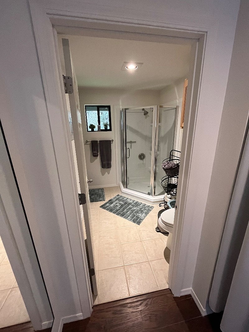 Bathroom with new shower, bath towels, hand towels, wash cloths, hairdryer, and a steamer iron.