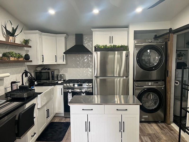 New full size refrigerator and washer/dryer assembly.