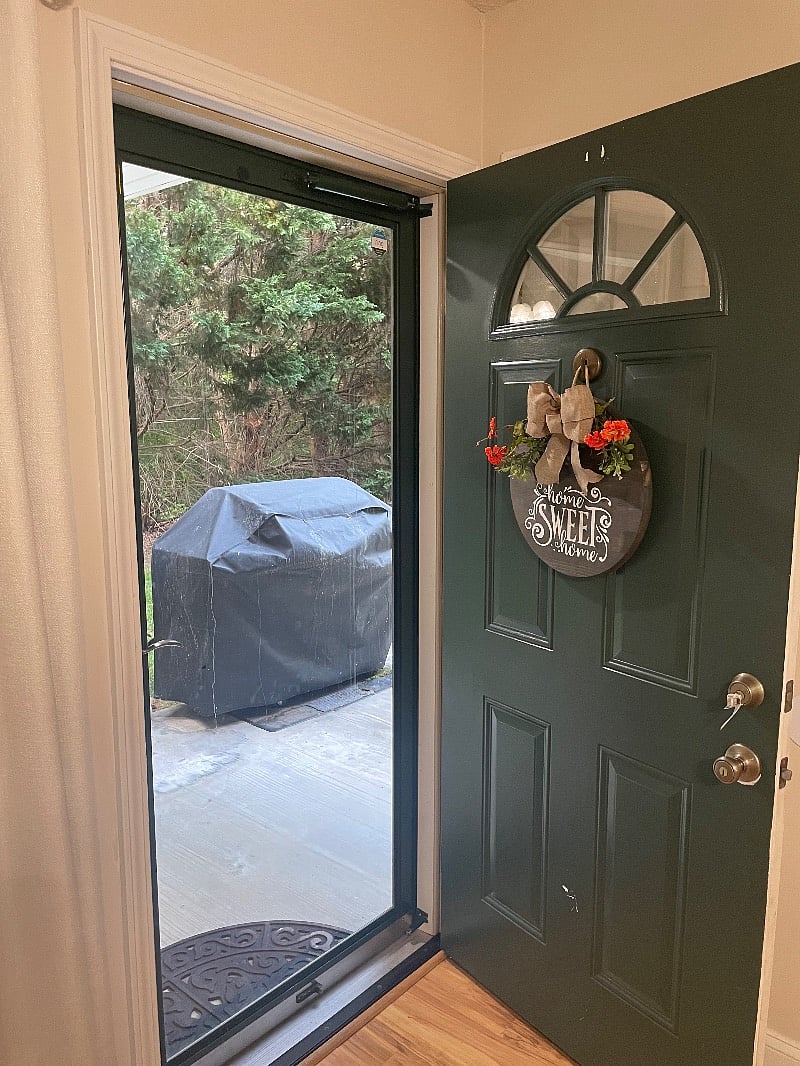 Front door with outdoor grill on the porch 

