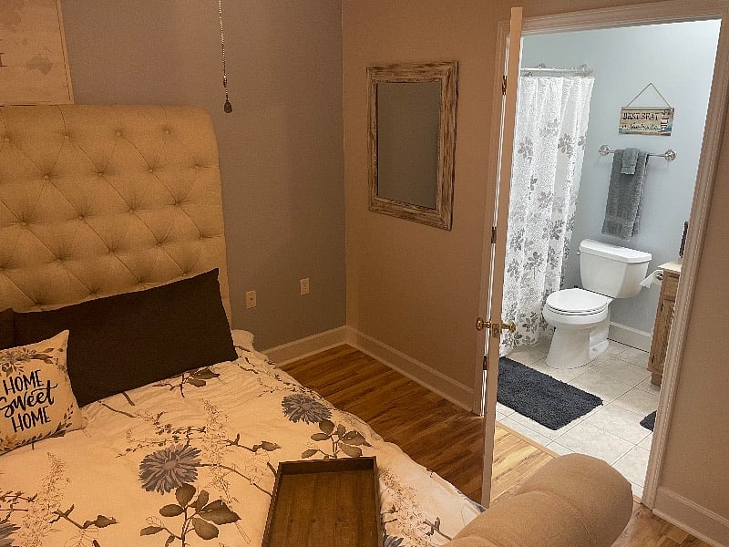 Master bedroom with view into the bathroom with accessible door 