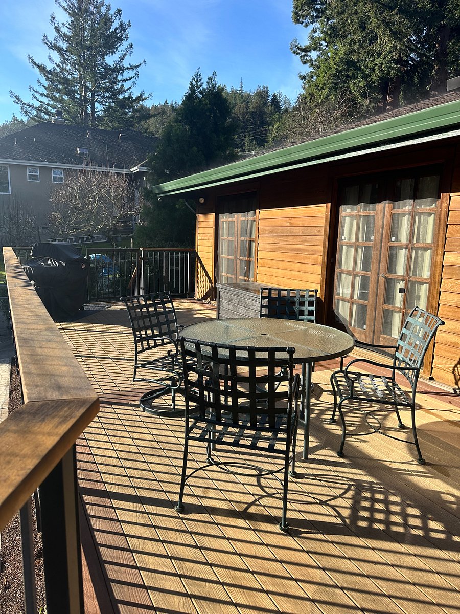Back Deck with table, chairs, umbrella, storage, and BBQ. Deck is fully fenced and accesible from each bedroom and the Den. The sun shines out here for several hours a day.