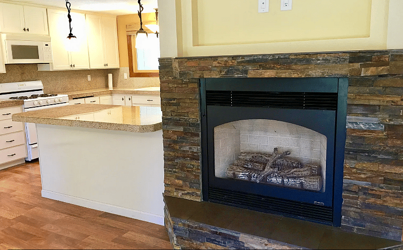 Natural stone surrounded gas fireplace with tile bench. TV wasn't hung yet, but is now.