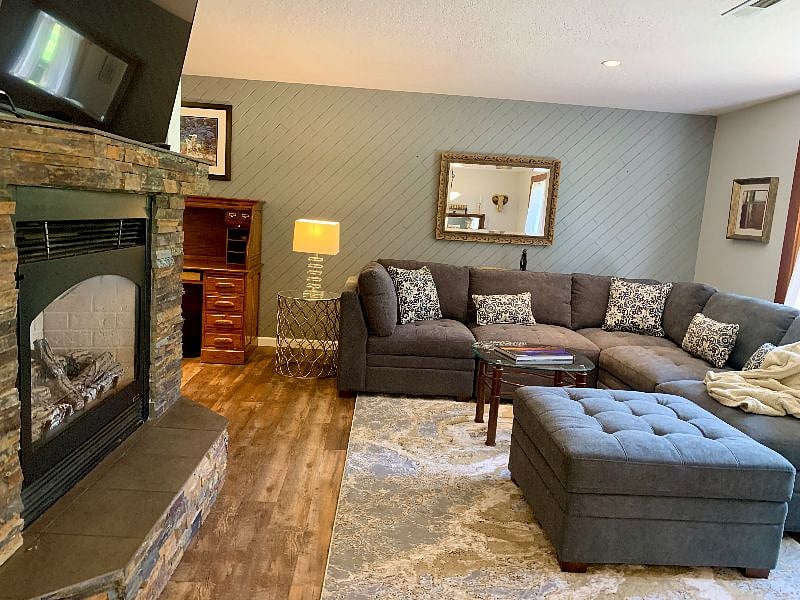 Living room is so easy to relax in. Natural light, new large L shape couch and ottoman. Picture window with bench seat, gas fireplace, and smart tv on a mount that swivels, tilts and turns for your ultimate comfort.