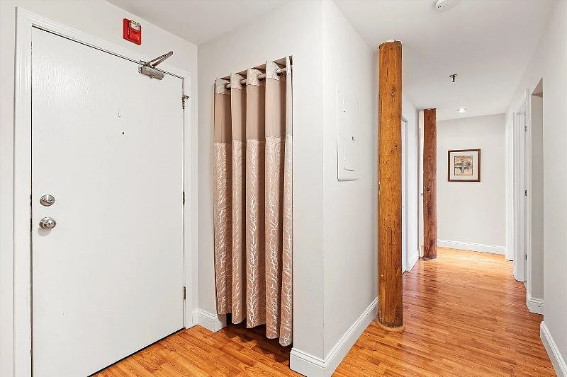 Apartment entrance and entryway closet leading to main hallway in apartment