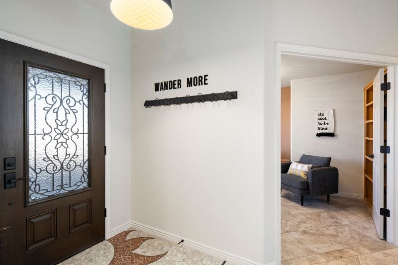 Front Entry and door to dedicated office space with TV, Desk and sofa.